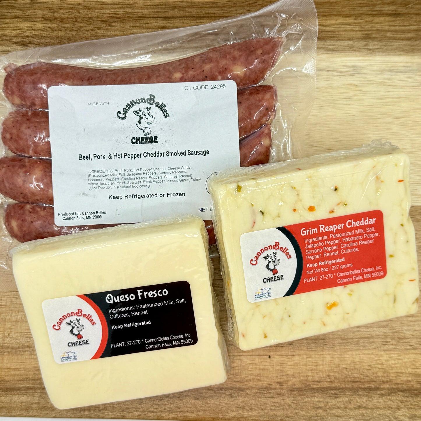 Contents of the CannonBelles Cheese Hot Box, including Queso Fresco cheese, Grim Reaper cheddar, hot pepper and cheddar smoked sausages, and Treats by T Ghost Pepper Sauce (not shown in this photo).