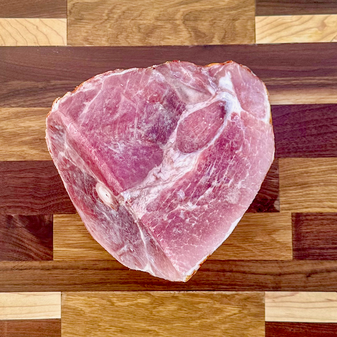 A smoked half-ham from Fertile Acreage Farms showcasing the color and marbling of their heritage pork.