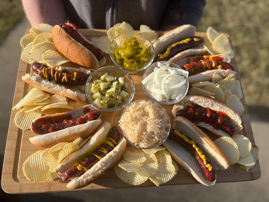 American Wagyu hot dogs on a plater with toppings.