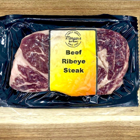 Packaged beef ribeye steak from Morgan's Meat Market on a wooden background