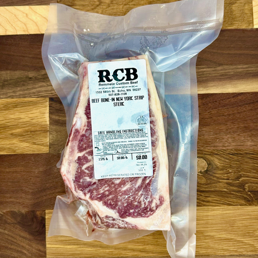 Packaged wagyu cross beef new york strip steaks from Remmele Custom Beef sitting on a cutting board