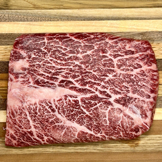 A flat iron steak from Verlinde Farms on a cutting board, showcasing the incredible marbling of American Wagyu beef.