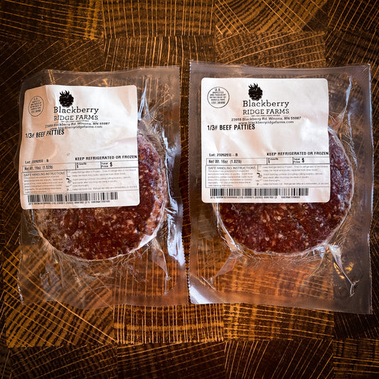 Two packages of 1/3 pound burger patties (1 pound per pack) from Blackberry Ridge Farms sitting on a cutting board.