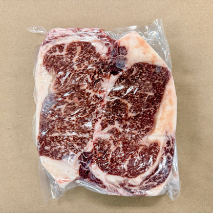 A 2-pack of well-marbled boneless ribeye steaks from Backstreet Market on a brown butcher paper background