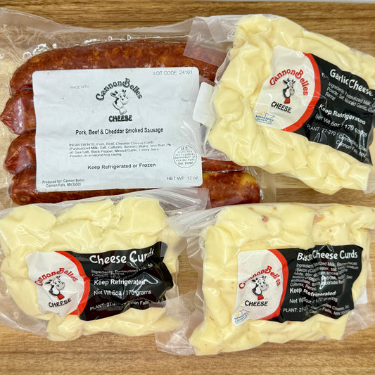 Contents of the CannonBelles Cheese Curds and Brats box, including cheddar smoked sausages, garlic cheese curds, white cheddar cheese curds, and bacon cheddar cheese curds.