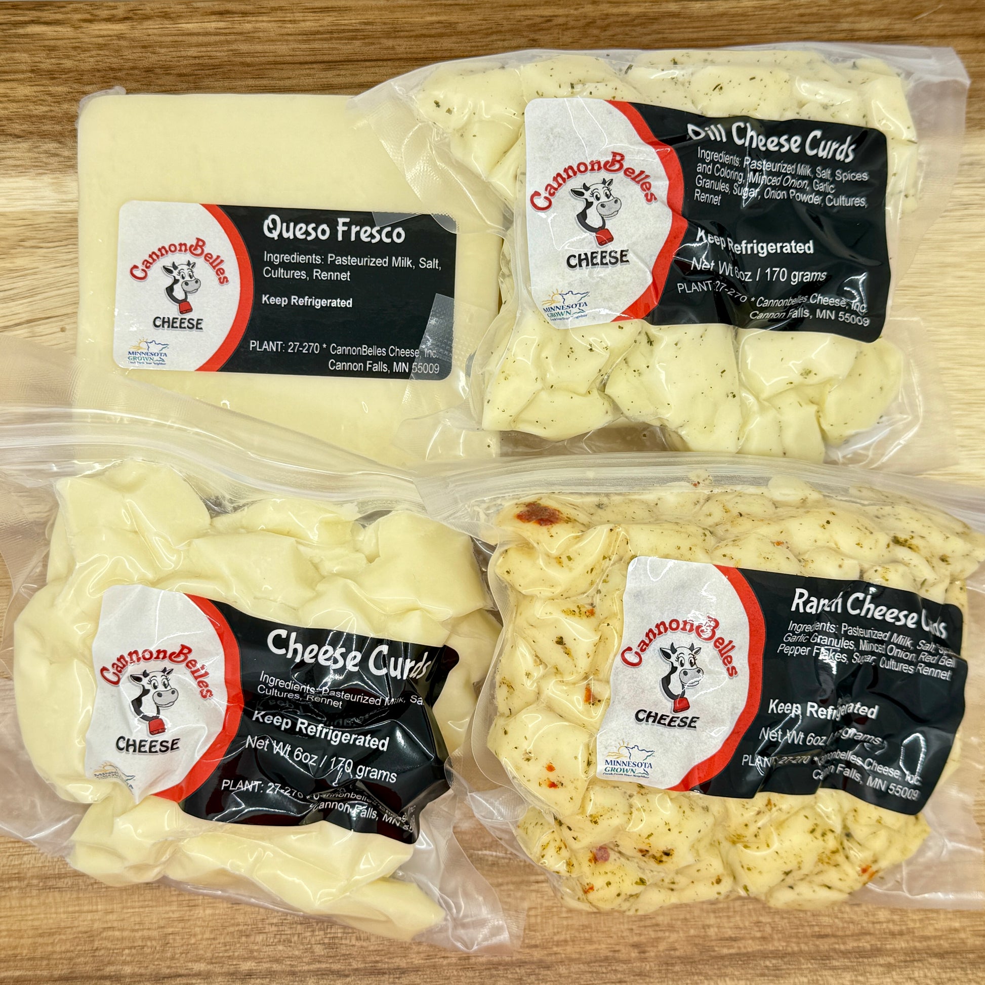 Contents of the CannonBelles Cheese Curds and Queso box, including queso fresco cheese, dill cheese curds, white cheddar cheese curds, and ranch cheese curds. 