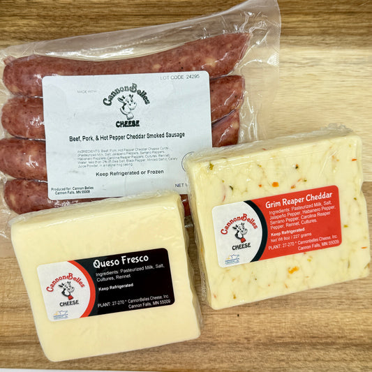 Contents of the CannonBelles Cheese Hot Box, including Queso Fresco cheese, Grim Reaper cheddar, hot pepper and cheddar smoked sausages, and Treats by T Ghost Pepper Sauce (not shown in this photo).