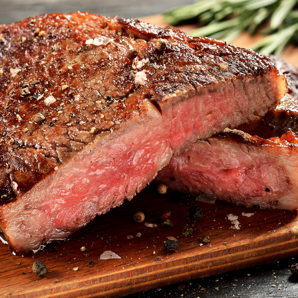 Grilled steak on a wooden cutting board with rosemary