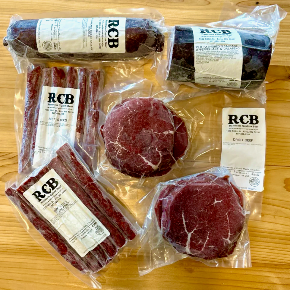 The Entertainer Box including dried beef, summer sausage, old-fashioned all-beef sausage, and beef sticks displayed on a wooden surface.