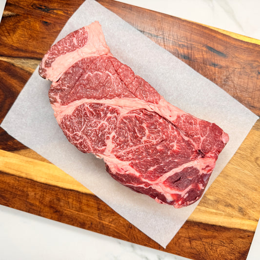 An American Wagyu Chuck Roast from Verlinde Farms on a wooden cutting board with white paper underneath